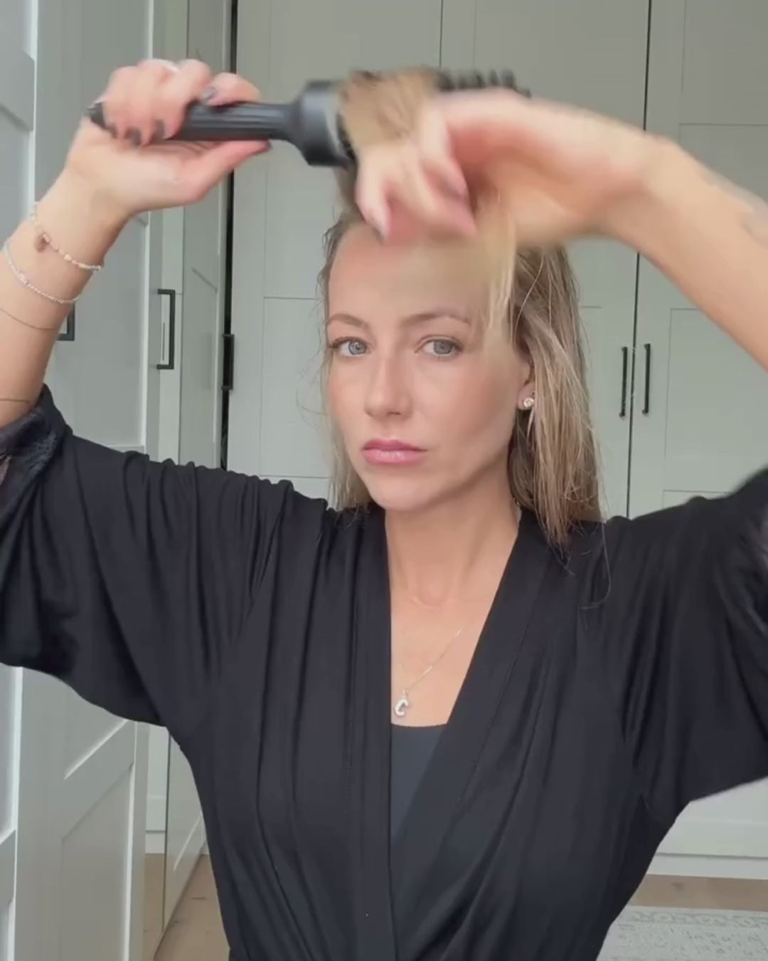 Frau föhnt sich den vorderen Teil ihrer Haare mit der Rundbürste von feschi