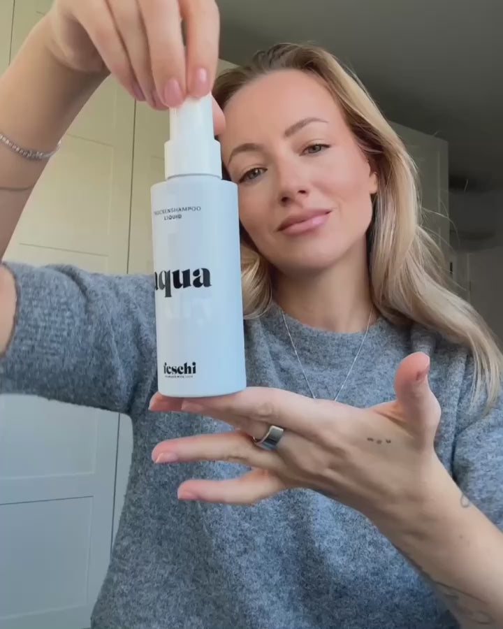 blonde Frau zeigt die Anwendung vom Aqua Dry Trockenshampoo Liquid