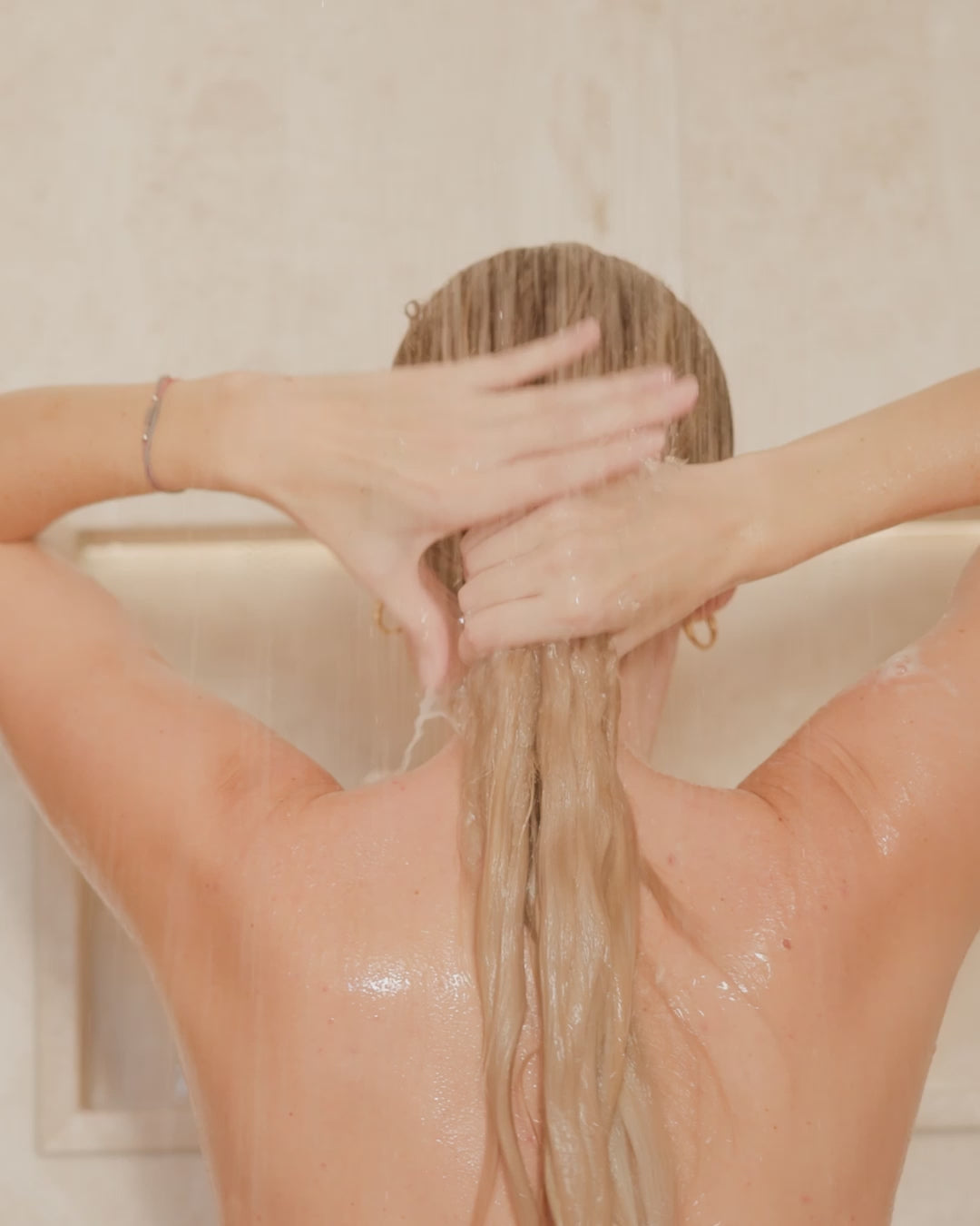Frau wäscht Shampoo aus