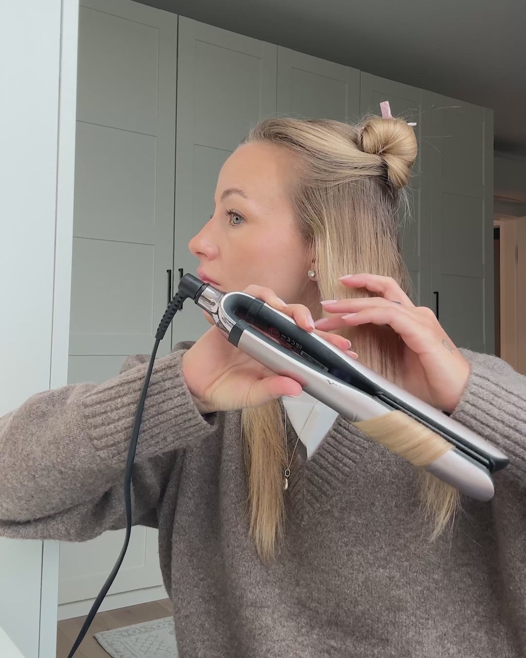 Video, wo sich Frau die Haare mit Glätteisen lockt