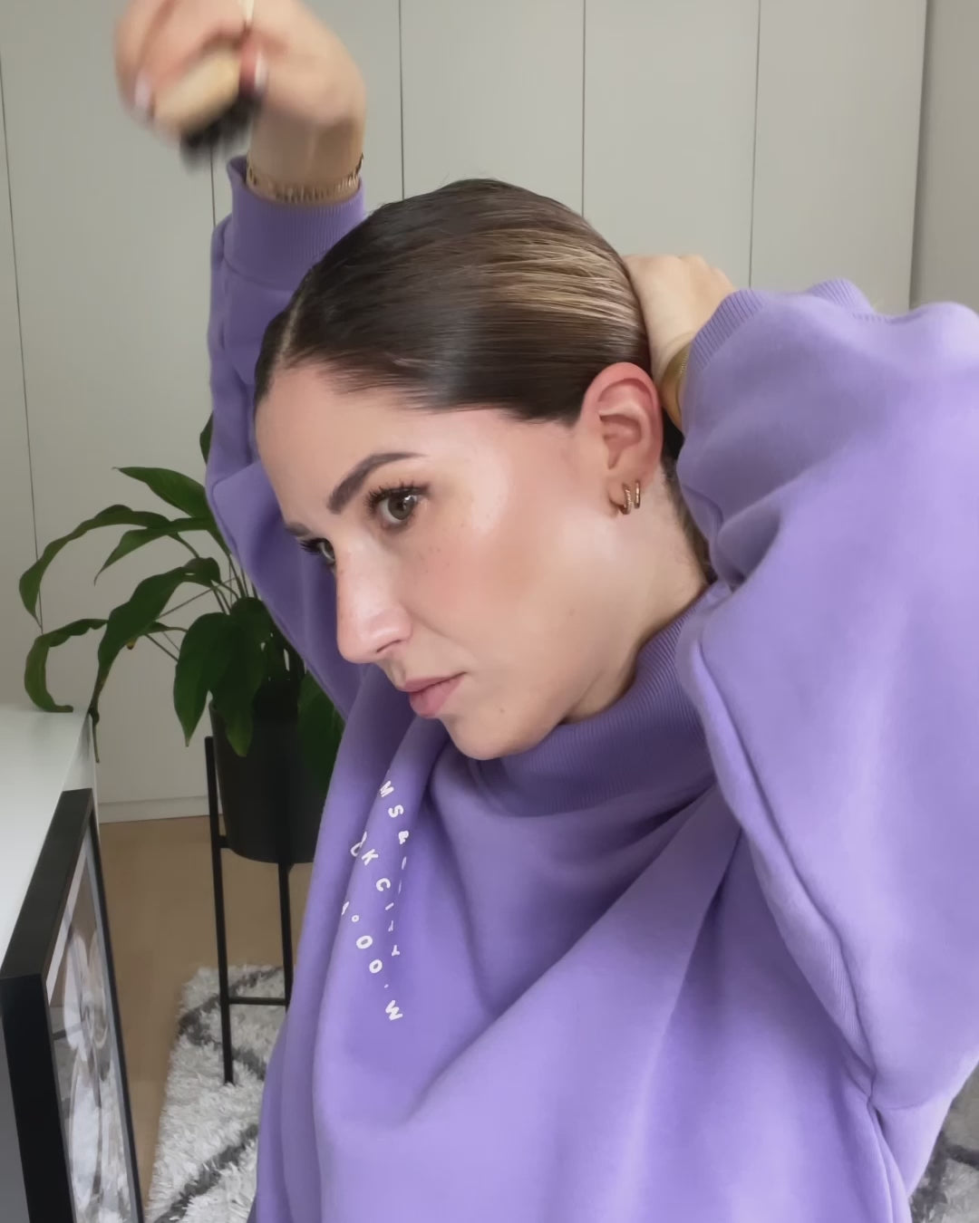 Frau bürstet sich die Haare mit einer Bürste glatt zurück