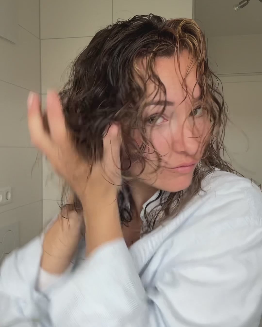 Frau knetet sich etwas in die Haare ein