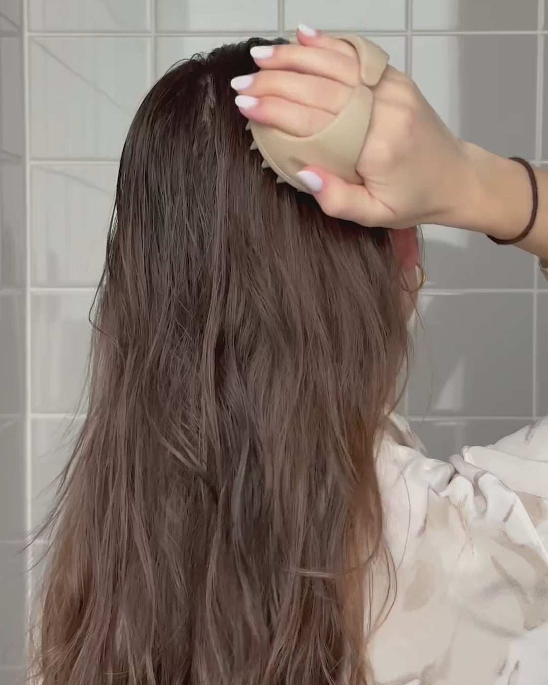 Frau massiert sich Kopfhaut mit scalp brush
