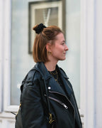 Frau seitlich mit kurzen Haaren, halbem Dutt, trägt das schwarze Scrunchie von feschi