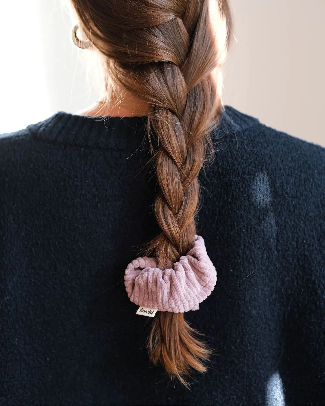 Frau von hinten mit geflochtenen Zopf, trägt ein Scrunchie von feschi