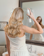 Frau zeigt ihre besonders glänzenden Haare von hinten nach der Anwendung vom feschi smooth & shine Anti-Frizz Spray.