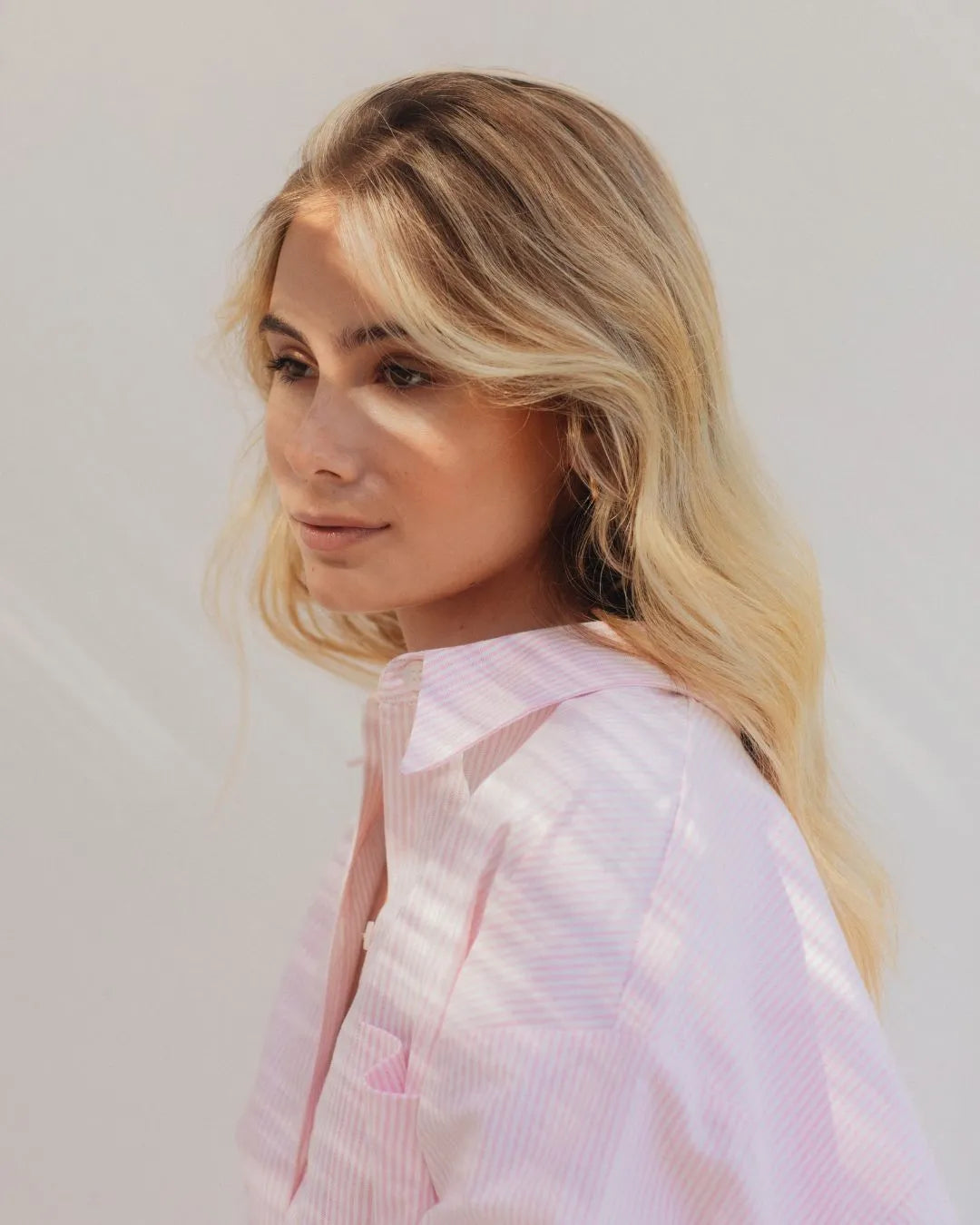 Frau mit blonden, welligen Haaren, seitlicher Blick