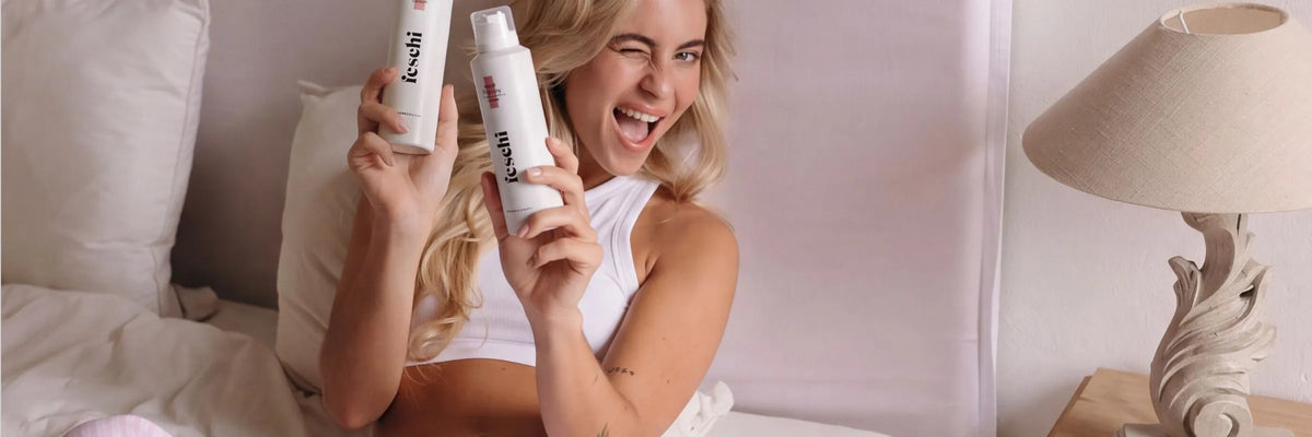 blondes Model hält 2x den feschi save the day - Trockenshampoo Schaum in den Händen und lächelt in die Kamera