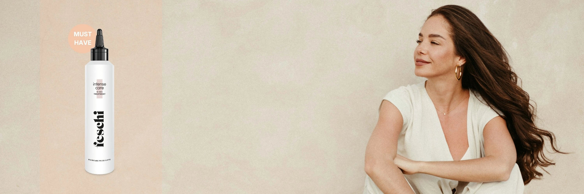 Frau mit dunklen, langen, gelockten Haaren schaut auf Seite und sitzt vor beigen Steinwand