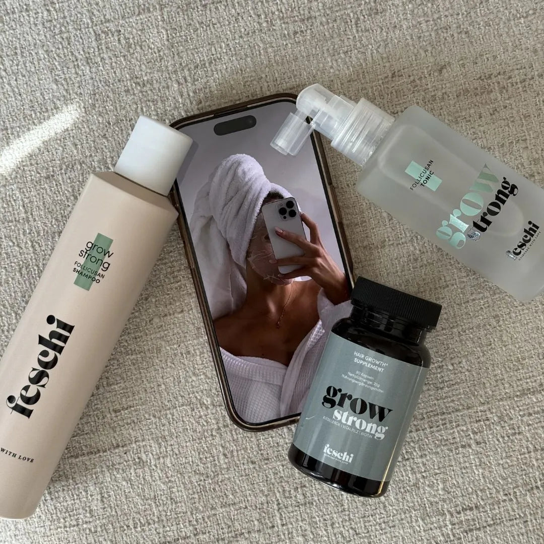 feschi grow strong Produkte gegen Haarausfall liegen neben Handy