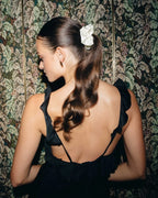 Elegant gekleidete dunkelhaarige Frau mit Seidenscrunchie Zopf 