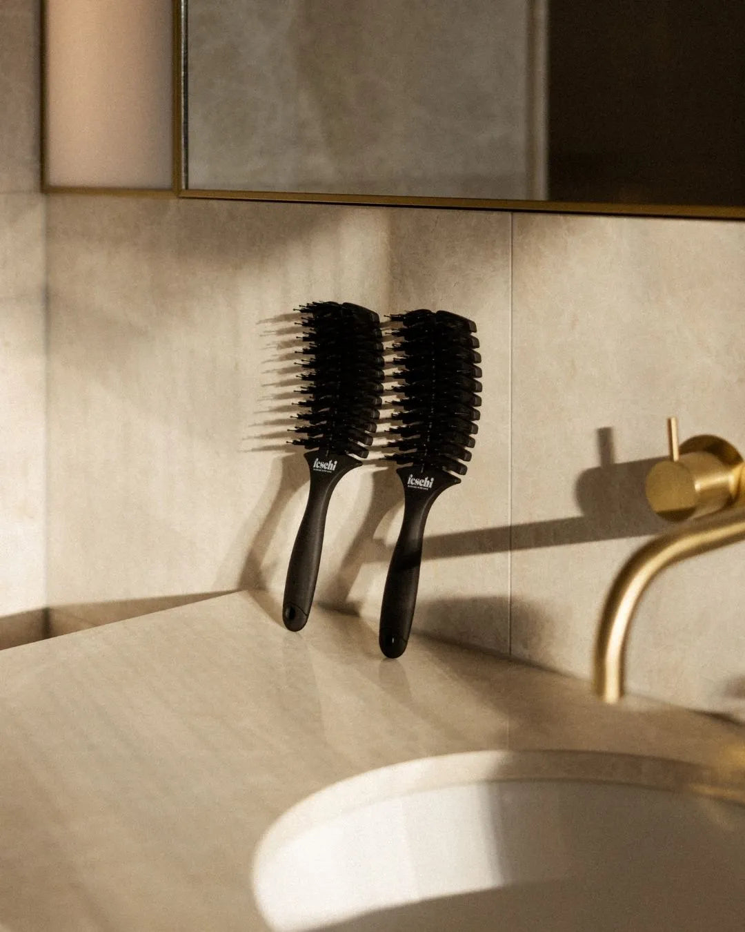 Die ergonomische Haarbürste von feschi, angelehnt im Badezimmer, ist nicht nur ein optischer Hingucker, sondern auch für jede Haarstruktur geeignet