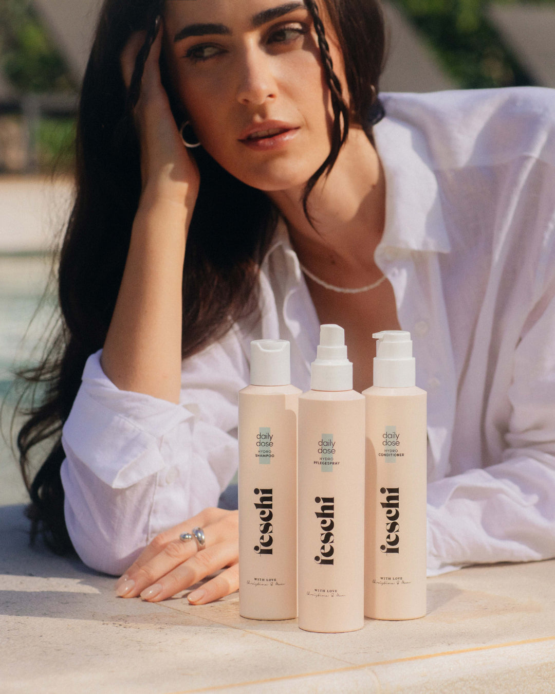 feschi daily dose Serie für geschmeidiges Naturhaar wird am Pool präsentiert.