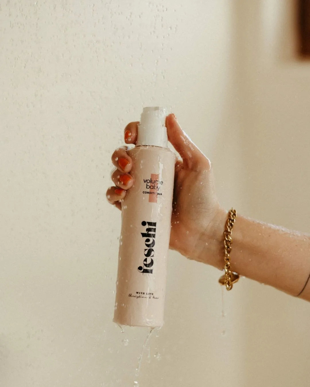Frau hält volume baby Conditioner von feschi unter der Dusche in der Hand