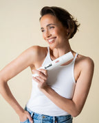 Frau mit coolem Kurzhaar-Schnitt hält Schaumfestiger in der Hand