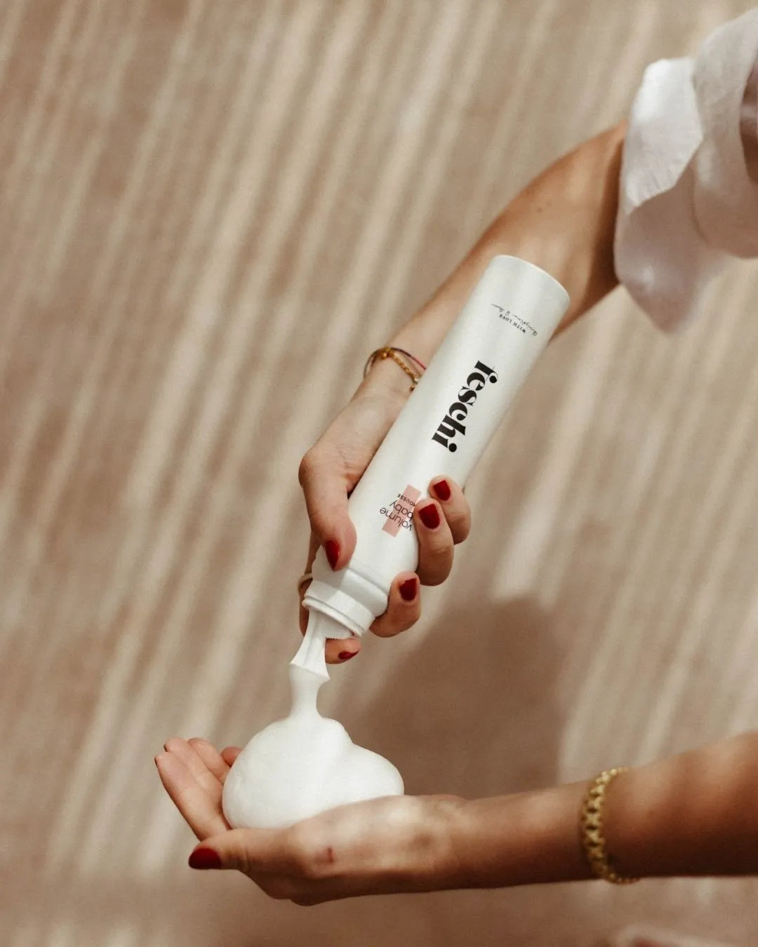 Das Volumen Mousse von feschi wird gerade in die Hand gesprüht