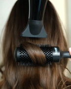 Haare von hinten zu sehen, wo man gerade ein Blow Out mit Föhn und feschi Rundbürste macht