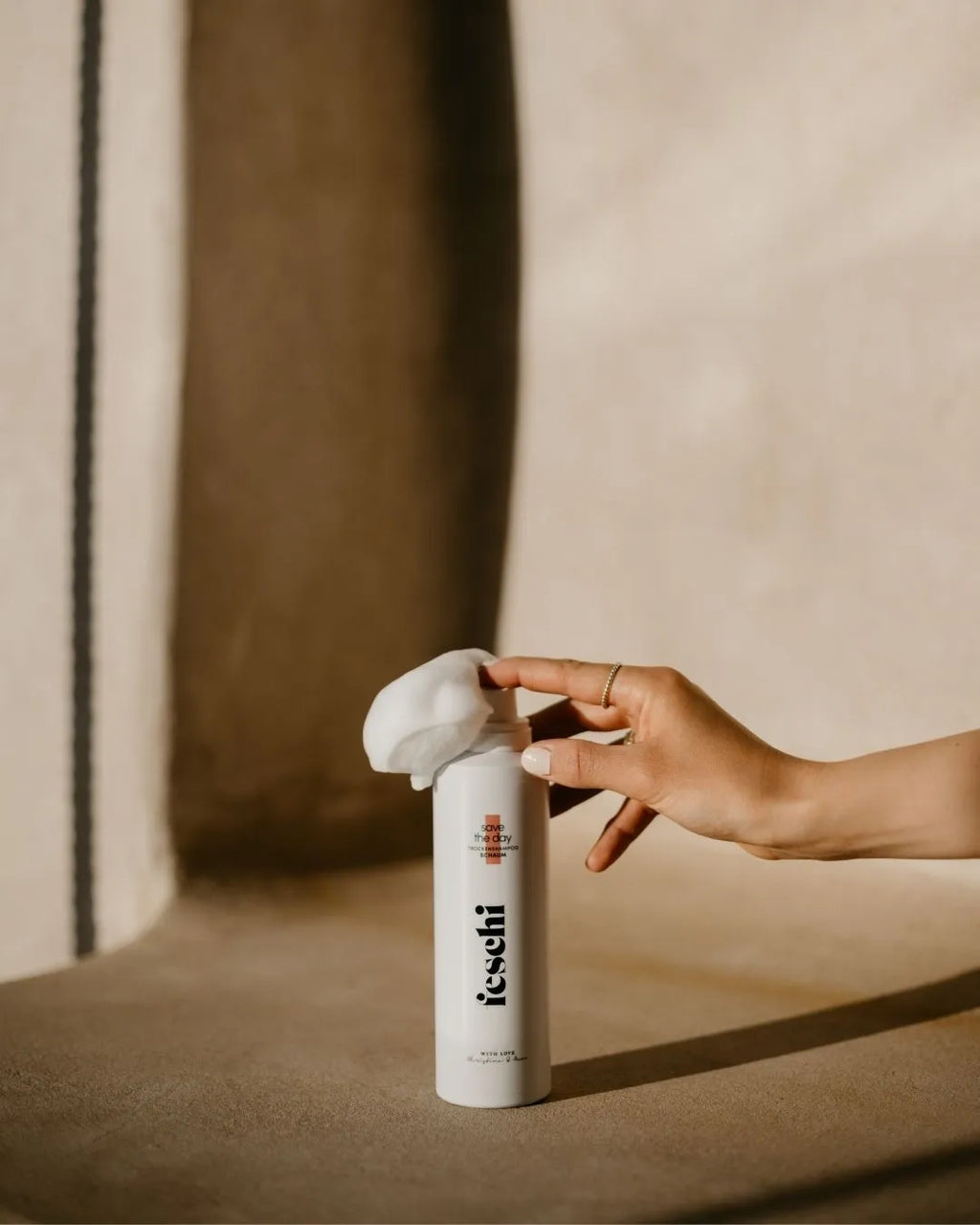 Trockenschampoo Schaum von feschi steht auf Steinboden und Schaum kommt aus Dose heraus