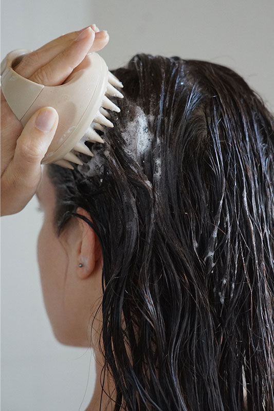 Die scalp brush in der Anwendung unter der Dusche